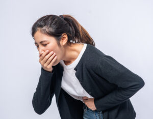 Vomiting girl due to side effects of peptic ulcer in digestive tract